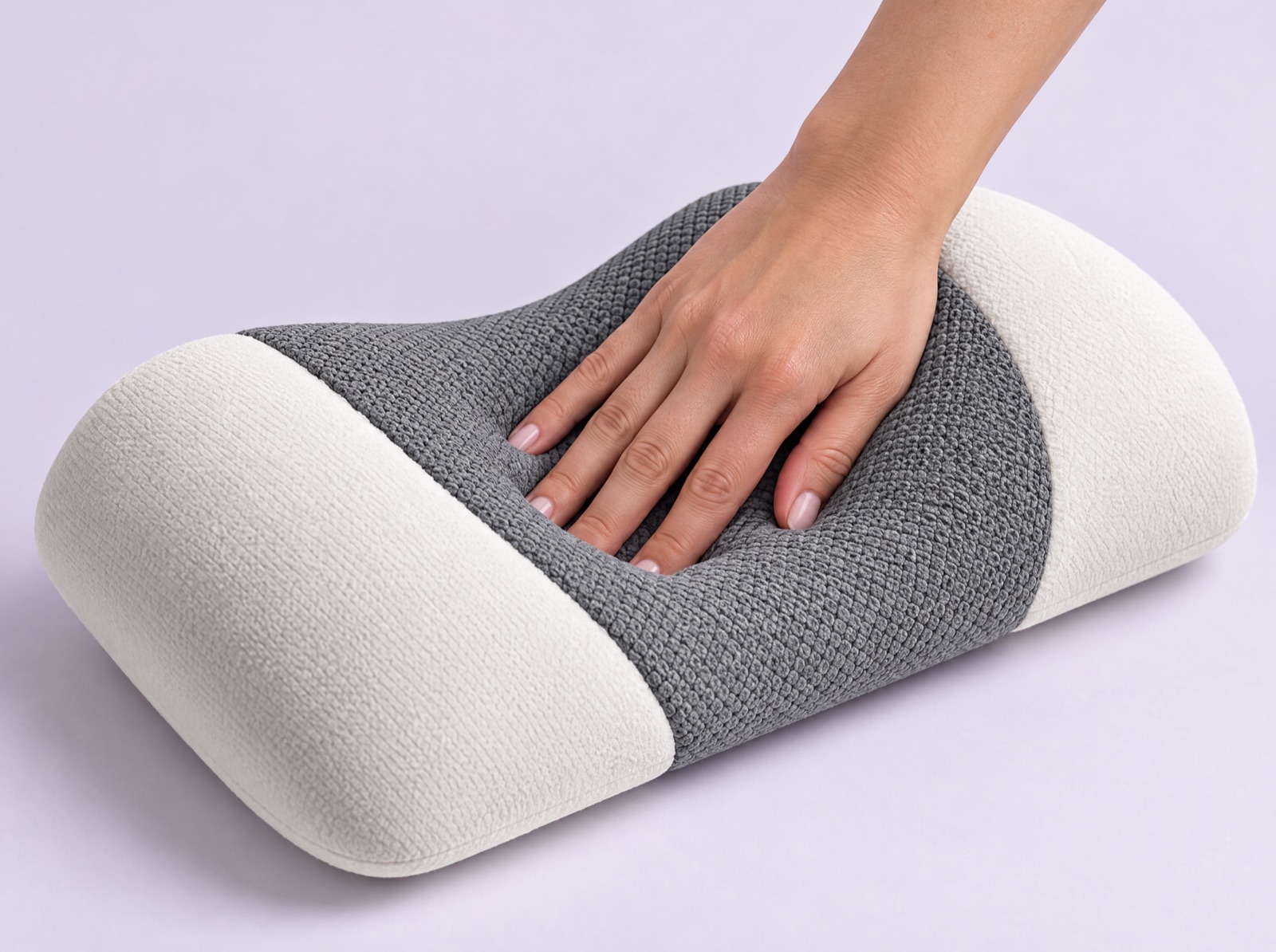 A hand pressing into the dense memory foam of the Volara Pro